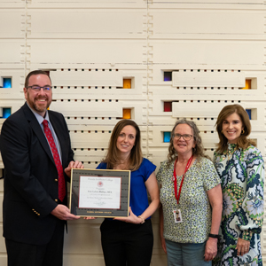 Dr. Jeremy Martin hands Erin Lasala Phillips a plaque